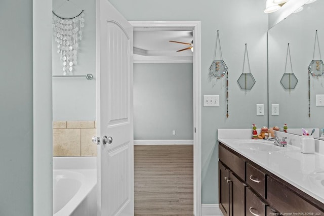 bathroom with vanity, ceiling fan, wood-type flooring, and a washtub