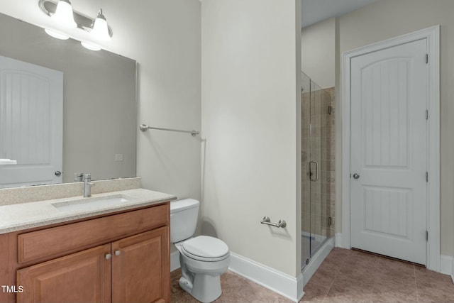 bathroom featuring tile patterned flooring, vanity, toilet, and a shower with door