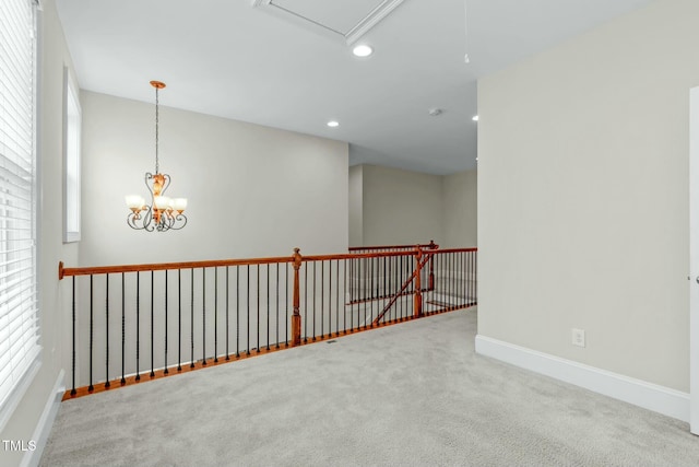 empty room featuring carpet flooring, a chandelier, and plenty of natural light