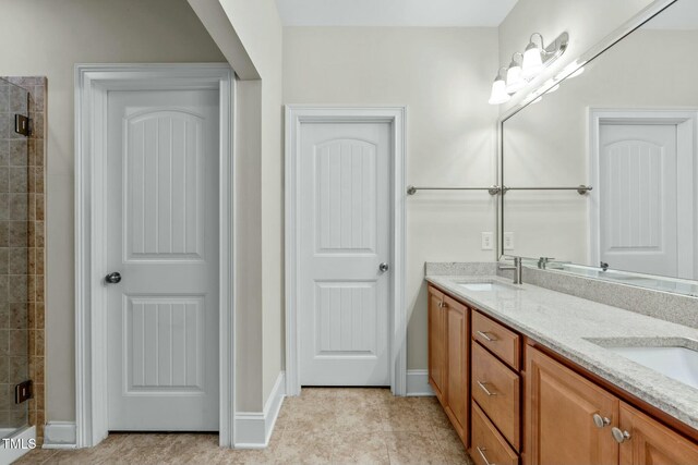 bathroom with tile patterned flooring, vanity, and walk in shower