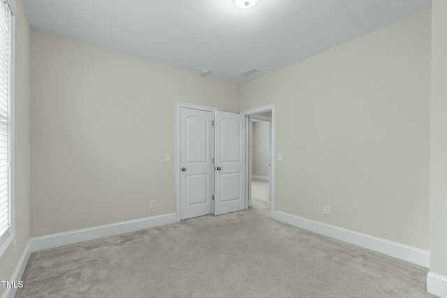 unfurnished room with light carpet