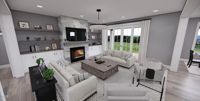 living room featuring light wood-type flooring and a fireplace