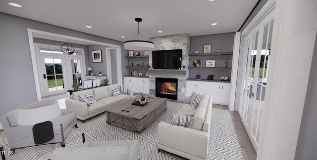 living room with a chandelier, a fireplace, and light hardwood / wood-style flooring