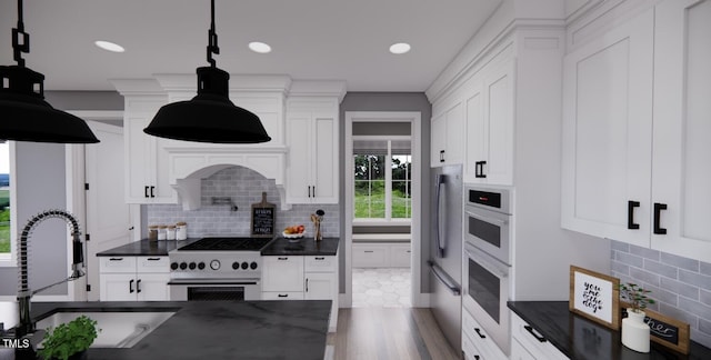 kitchen featuring white cabinetry, stainless steel appliances, decorative backsplash, sink, and hanging light fixtures