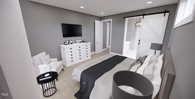 bedroom featuring light colored carpet and a barn door