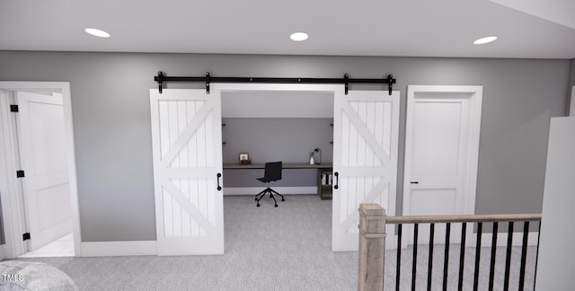 bedroom with light carpet and a barn door