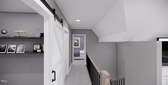 hall featuring light colored carpet, a barn door, and vaulted ceiling