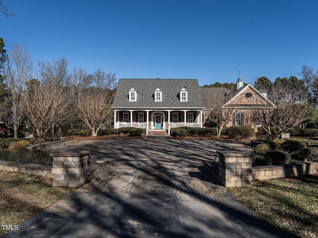 cape cod-style house featuring a porch