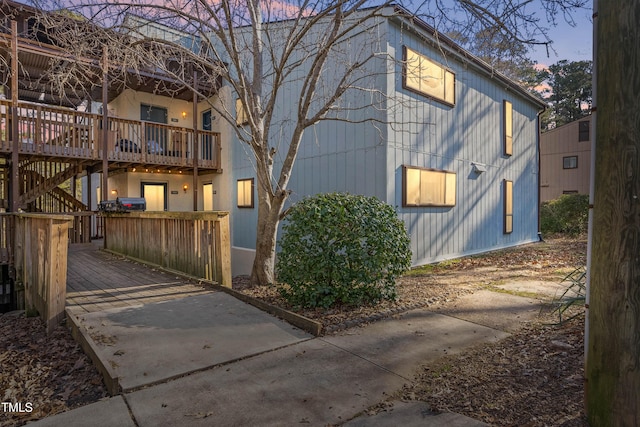 property exterior at dusk featuring a deck