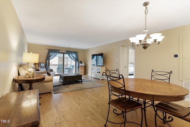 dining area with a notable chandelier and light hardwood / wood-style floors