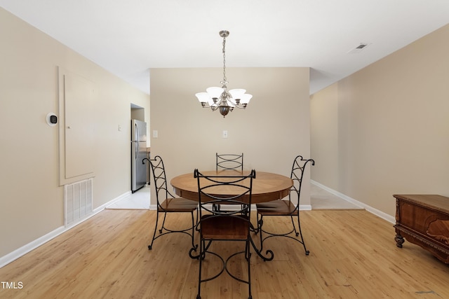 dining room featuring an inviting chandelier and light hardwood / wood-style flooring