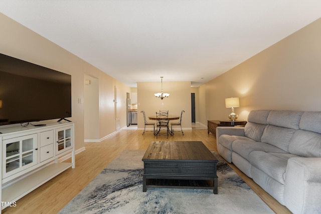 living room with a chandelier and light wood-type flooring