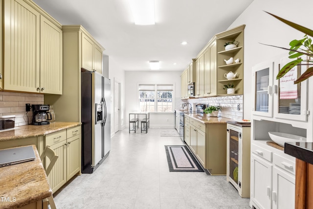 kitchen featuring appliances with stainless steel finishes, beverage cooler, backsplash, and cream cabinets