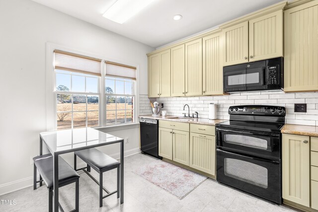 kitchen featuring sink, cream cabinetry, tasteful backsplash, and black appliances