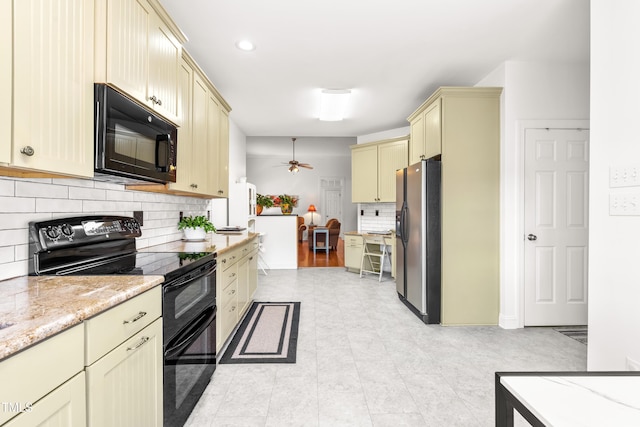 kitchen featuring cream cabinetry, ceiling fan, decorative backsplash, light stone counters, and black appliances