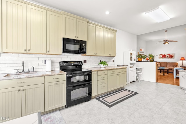 kitchen featuring black appliances, cream cabinetry, sink, and decorative backsplash