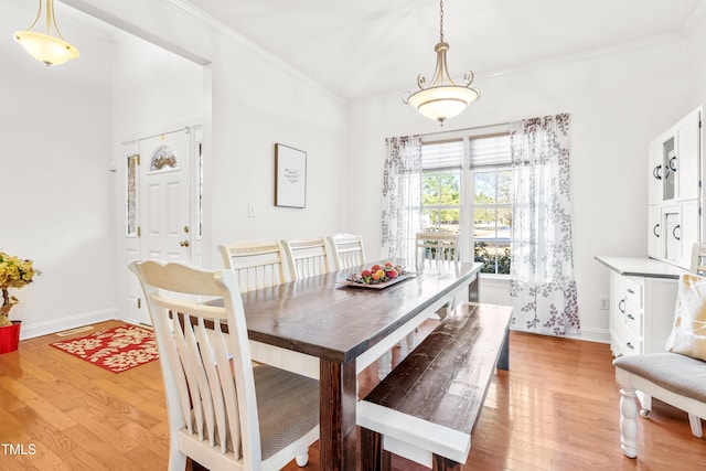 dining room featuring crown molding and light hardwood / wood-style flooring