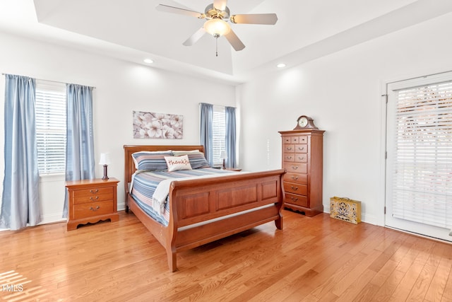 bedroom featuring ceiling fan, multiple windows, and light hardwood / wood-style floors