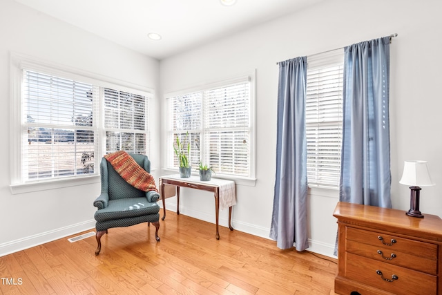 living area with light wood-type flooring and plenty of natural light