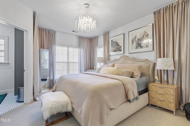 carpeted bedroom featuring a notable chandelier