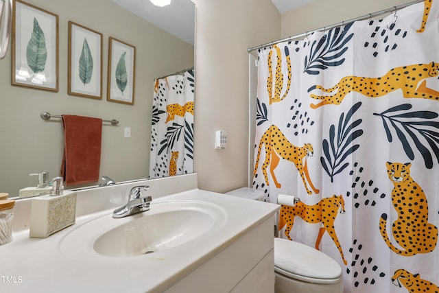 bathroom featuring a shower with shower curtain, vanity, and toilet