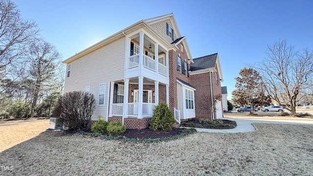 view of side of property featuring a balcony and a porch