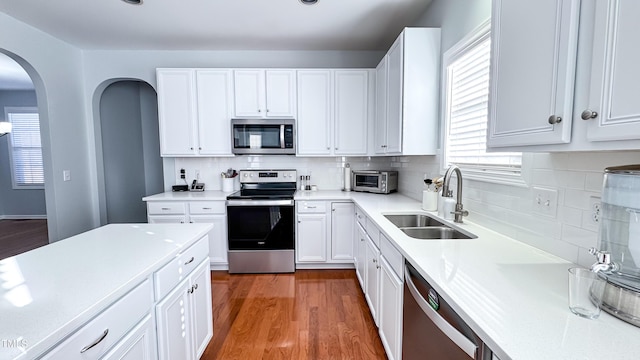 kitchen featuring white cabinets, backsplash, appliances with stainless steel finishes, and sink