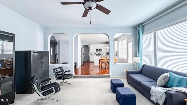 carpeted living room with ceiling fan