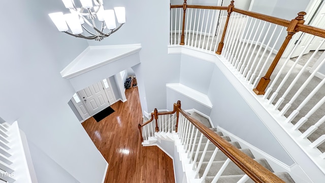 staircase featuring hardwood / wood-style floors and a chandelier