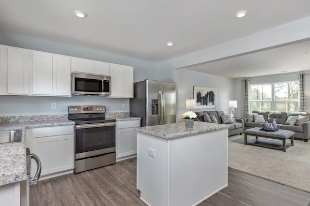 kitchen with white cabinetry, dark hardwood / wood-style flooring, a kitchen island, and stainless steel appliances