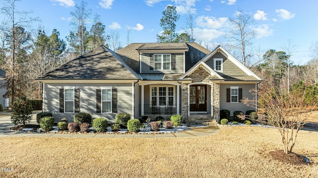 craftsman house with french doors and a front yard