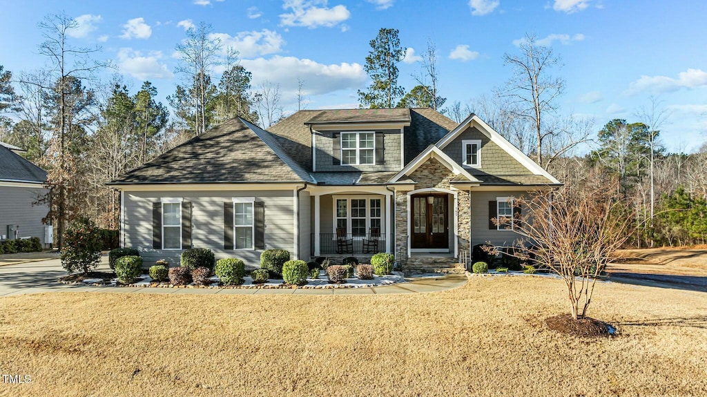 craftsman house with covered porch and a front lawn