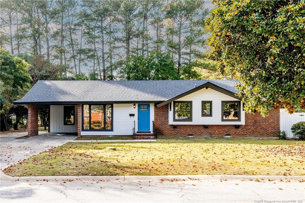 ranch-style house featuring a front yard and a carport