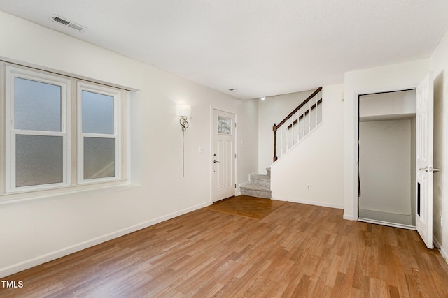 entryway with a textured ceiling and light wood-type flooring