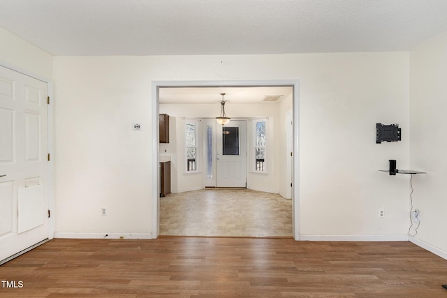 interior space featuring hardwood / wood-style flooring and a textured ceiling