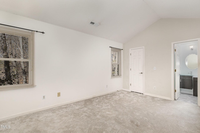 unfurnished bedroom with lofted ceiling and light carpet