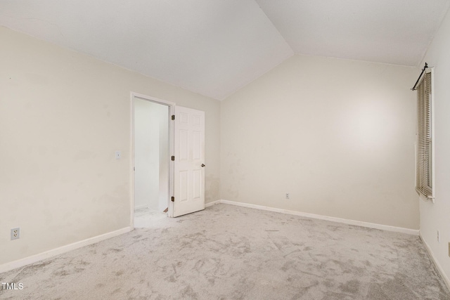 carpeted empty room with lofted ceiling