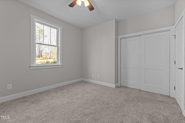 unfurnished bedroom featuring a closet, light carpet, and ceiling fan