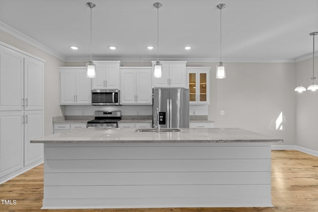 kitchen with a kitchen island with sink, pendant lighting, and appliances with stainless steel finishes