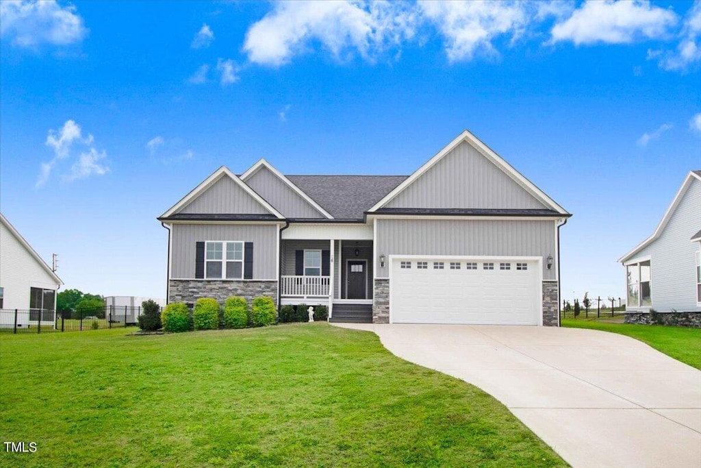 craftsman-style home featuring covered porch, a garage, and a front lawn