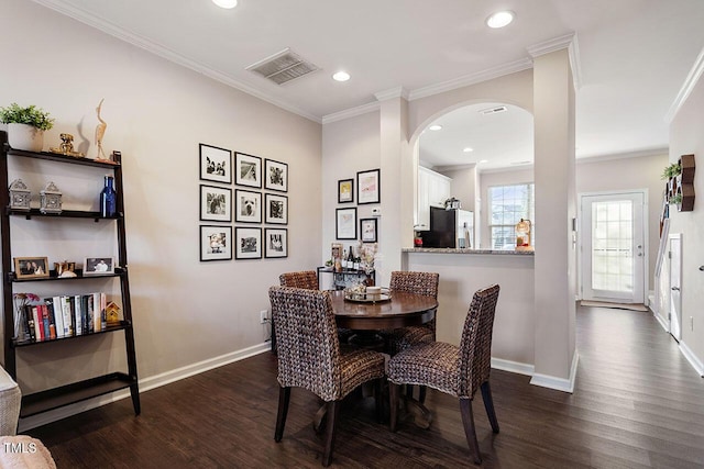 dining room featuring ornamental molding and dark hardwood / wood-style floors