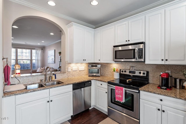 kitchen with light stone counters, sink, white cabinetry, and appliances with stainless steel finishes