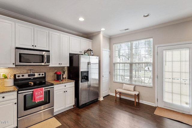 kitchen featuring appliances with stainless steel finishes, white cabinetry, decorative backsplash, dark hardwood / wood-style floors, and ornamental molding