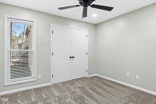 unfurnished bedroom with ceiling fan, a closet, and carpet floors