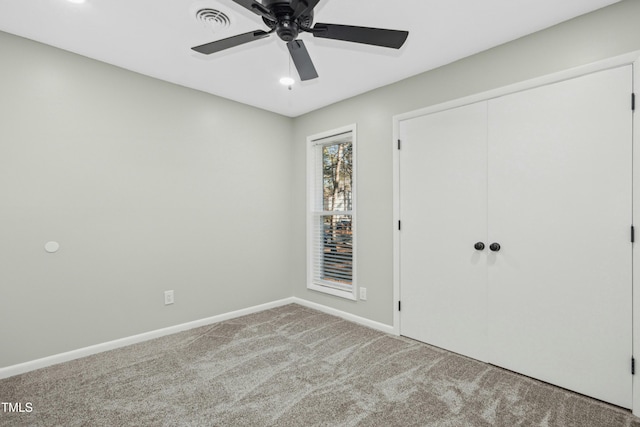 unfurnished bedroom featuring light carpet, ceiling fan, and a closet