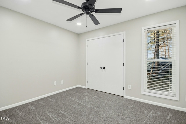 unfurnished bedroom with ceiling fan, a closet, and carpet floors