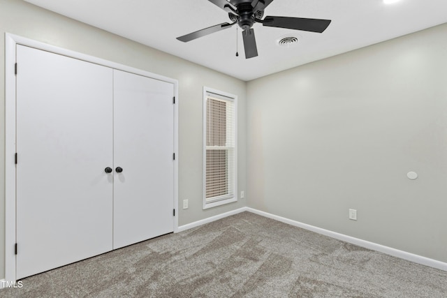 unfurnished bedroom with ceiling fan, a closet, and light carpet