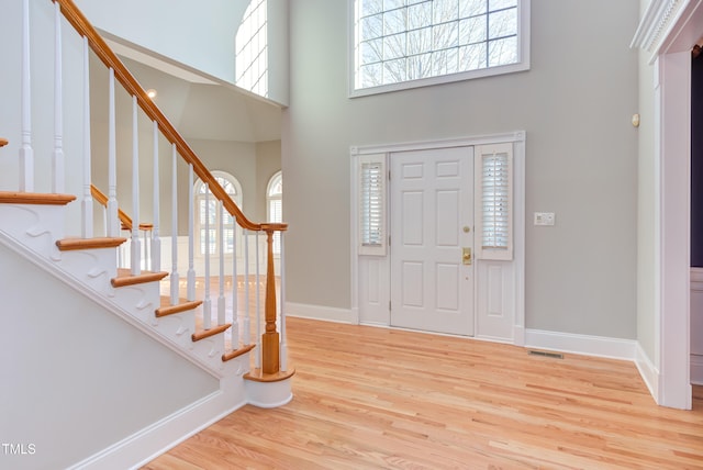 foyer entrance featuring a high ceiling and light hardwood / wood-style floors