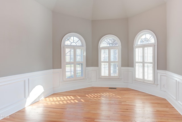 empty room featuring lofted ceiling and light hardwood / wood-style flooring