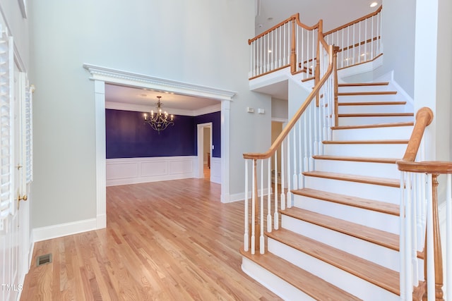 foyer featuring an inviting chandelier, ornamental molding, and wood-type flooring